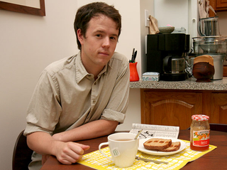 The fancy man rests a placemat beneath the precious tea to protect his beautiful table from any errant drips.